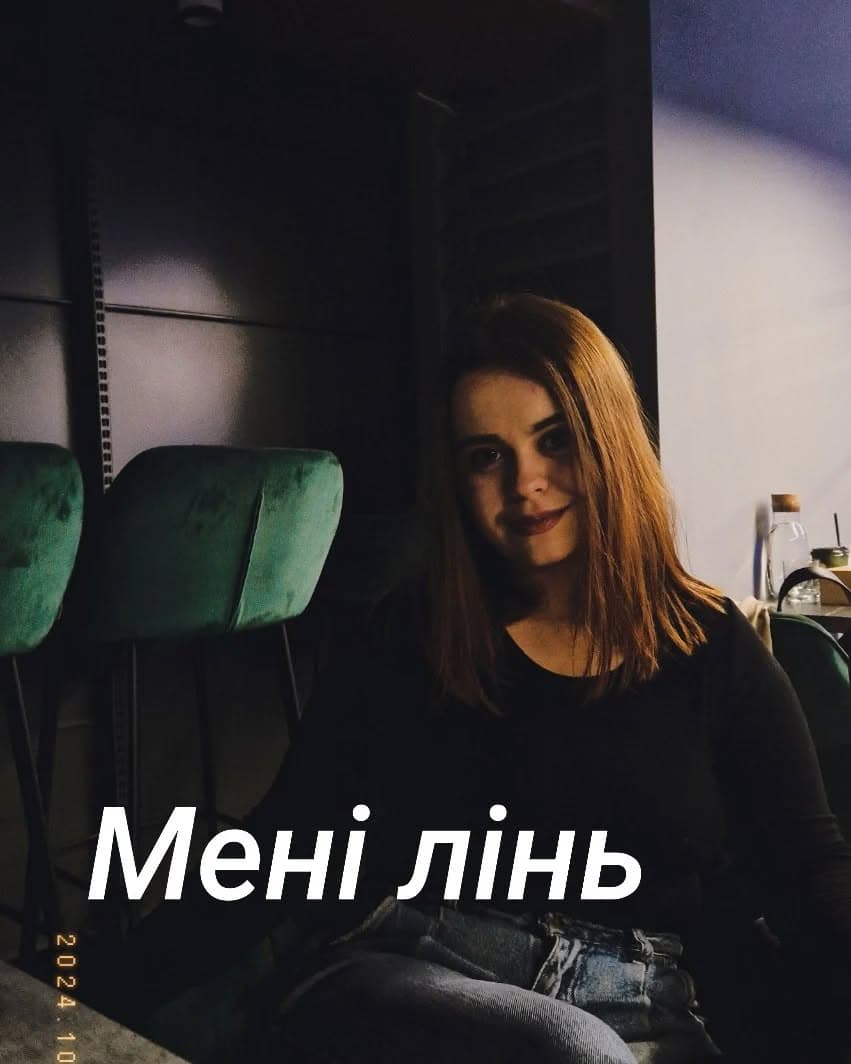 Марія Дерев'янченко сидить у напівтемній кімнаті біля зелених крісел; напис «Мені лінь»