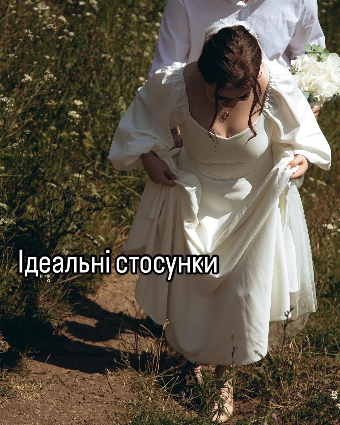 Дівчина в білій сукні йде польовою стежкою, позаду людина з букетом; напис «Ідеальні стосунки»